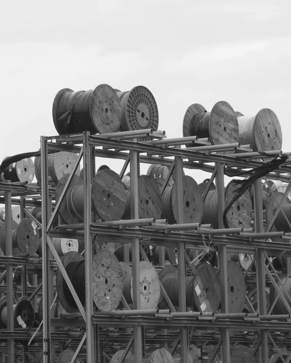 Tamburi de cablu stocați pe rafturi metalice
